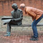 Mann redet mit einer sitzenden Skulptur